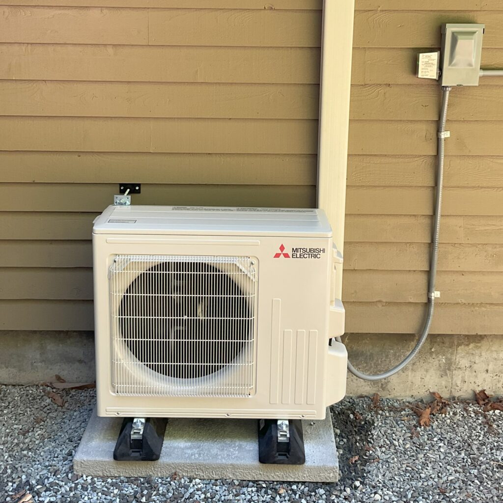 Mitsubishi ductless mini-split outdoor unit on a pad, installed by Sound Comfort Heating in Snohomish County, WA