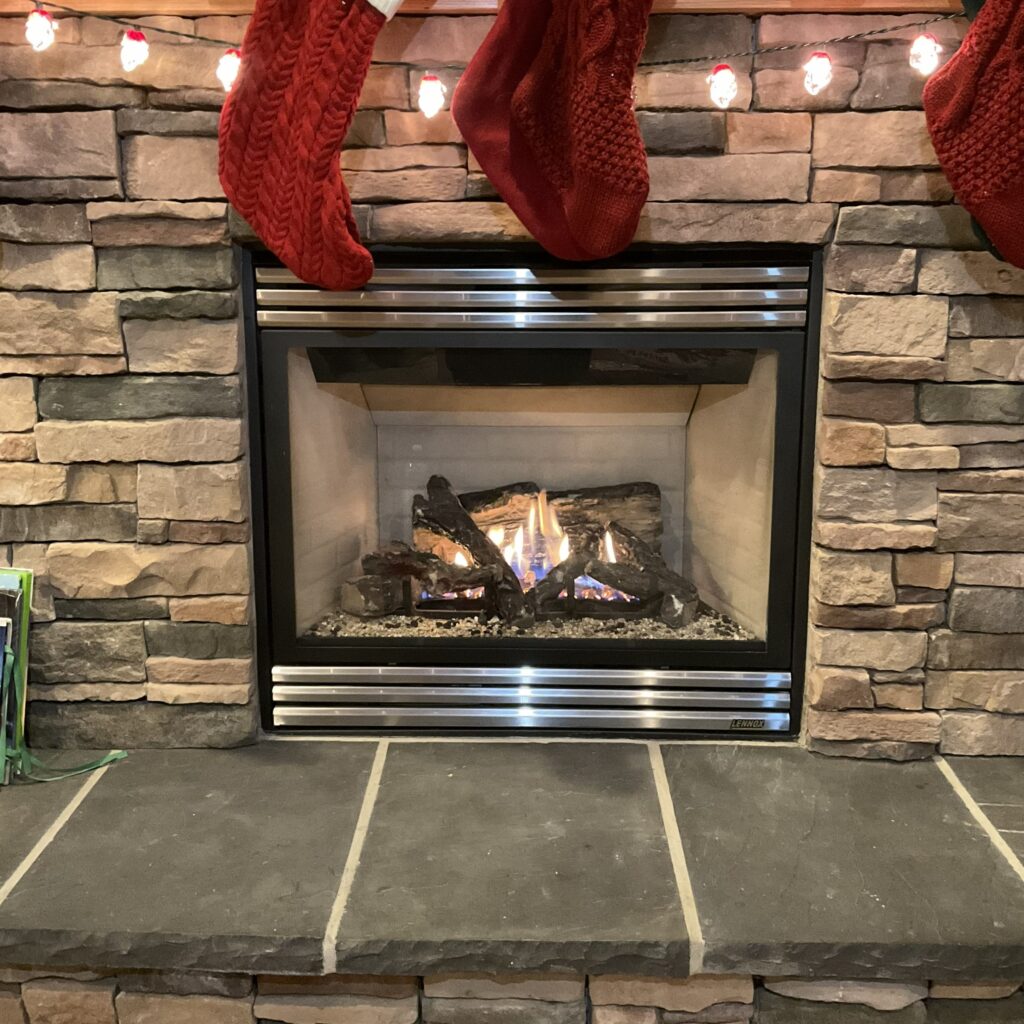 Gas fireplace insert glowing in a stone surround, gas fireplace repair in Everett