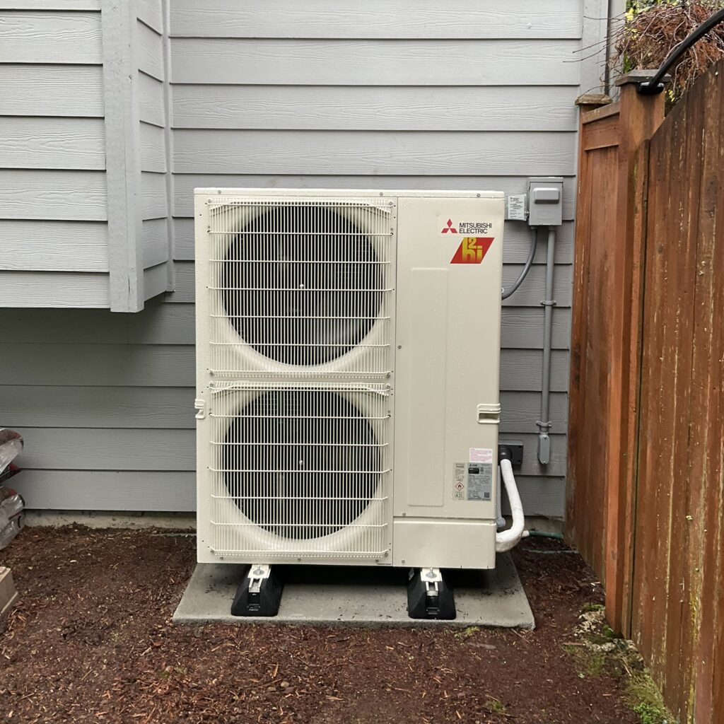 Mitsubishi heat pump outdoor unit installed beside a Snohomish County home